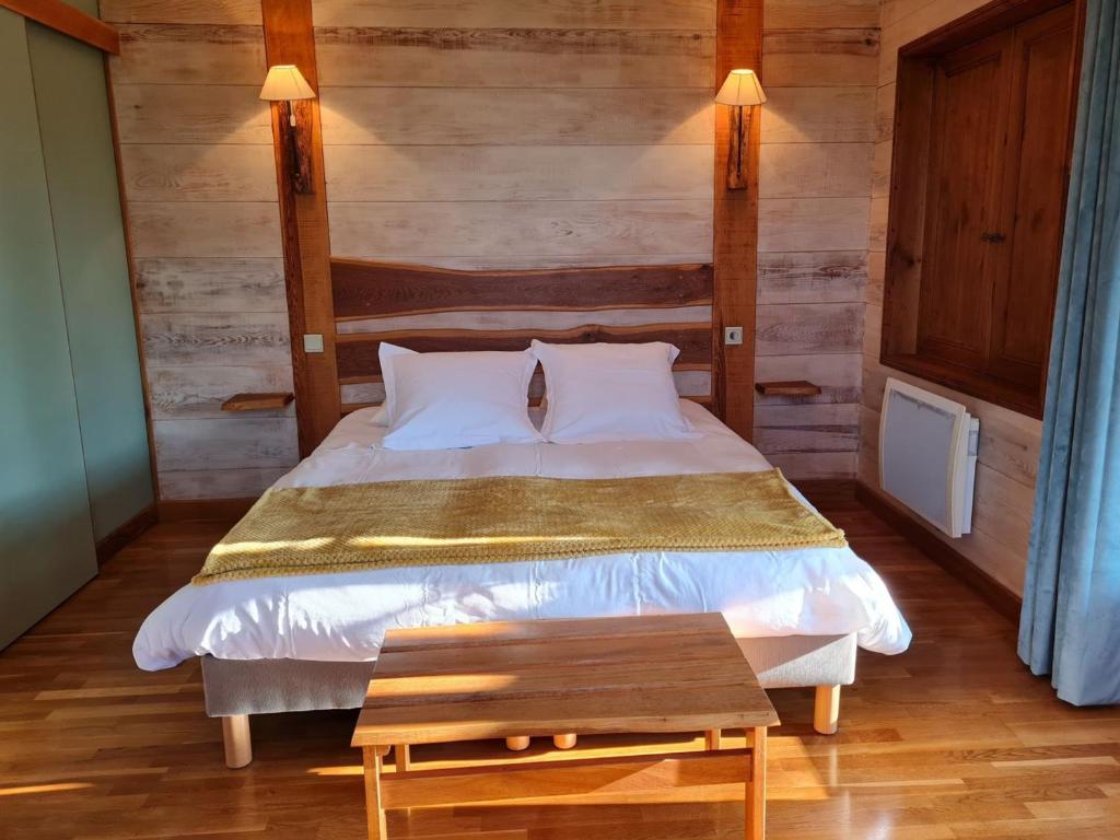 a bedroom with a bed and a wooden wall at Chambre familiale au cœur de la nature avec jardin et piscine privée, idéale pour explorer le Loiret - FR-1-590-265 in Vitry-aux-Loges