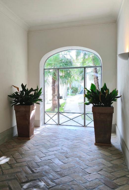 an open door with two potted plants in a hallway at Maison Rebecca - Superior Suite Apartment in Ravenna