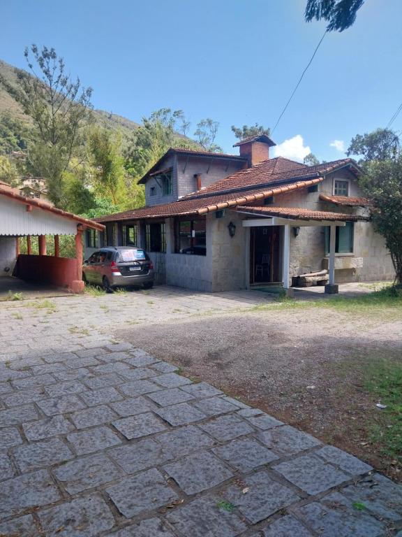 une maison avec une voiture garée devant dans l'établissement Casa das pedras, à Teresópolis