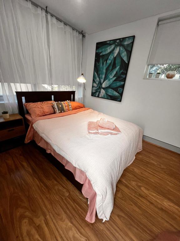 a bedroom with a large bed with white sheets at Bondi Stylish Bedroom Close to the Beach in Sydney