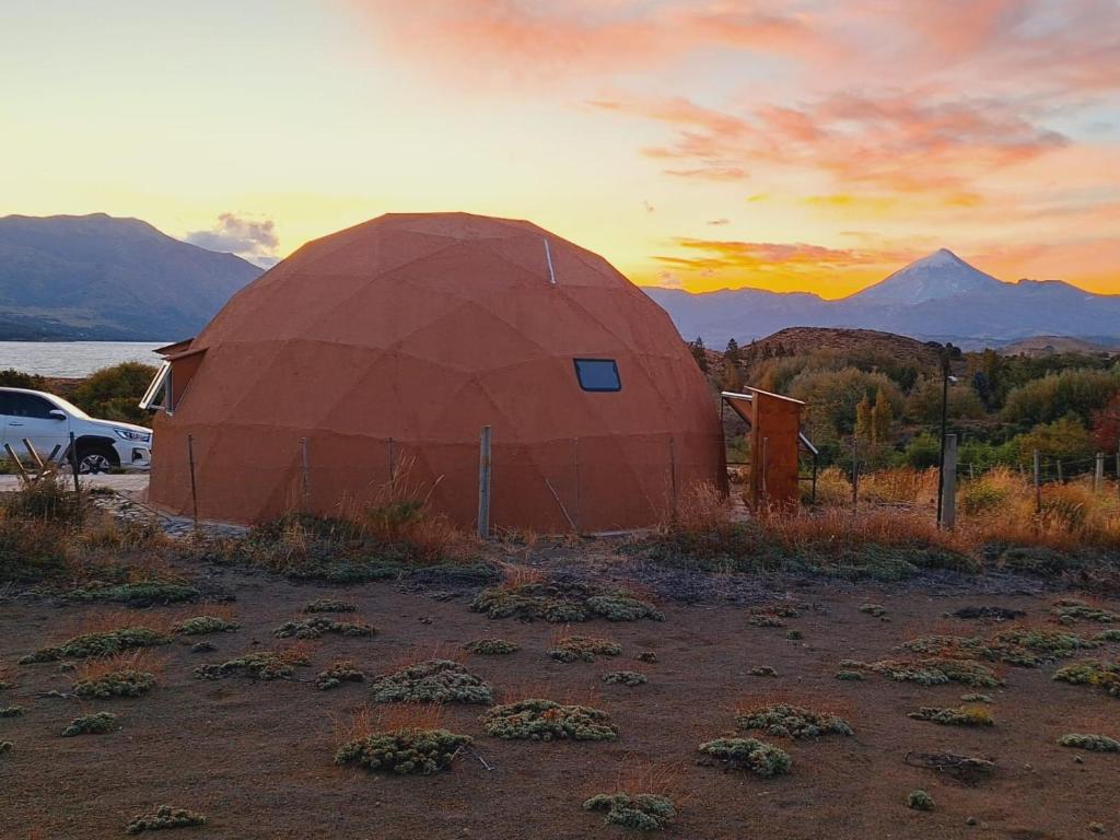 a large dome tent with a sunset in the background at Domo Kumelén Mahuida in Junín de los Andes