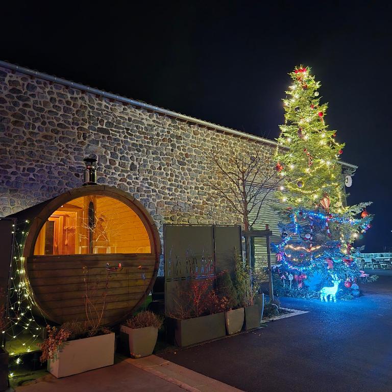 un arbre de Noël devant un bâtiment en briques dans l'établissement Logement Entier, à Saint-Jean-Lachalm
