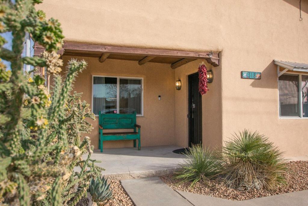 a front door of a house with a green bench at Grandma's Old Town Adobe House! Hot Tub & Pet Friendly & No Pet Fee! in Albuquerque