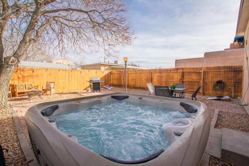 a hot tub in a backyard with a fence at Grandma's Old Town Adobe House! Private Hot Tub-Close to Old Town-Pet Friendly-No Pet Fee! in Albuquerque