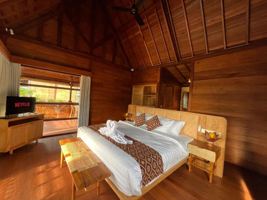 a bedroom with a bed and a television in it at Villa Gong bali in Ubud