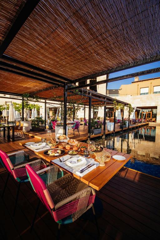 a wooden table with chairs and plates of food on it at The Romanos, a Luxury Collection Resort, Costa Navarino in Romanu