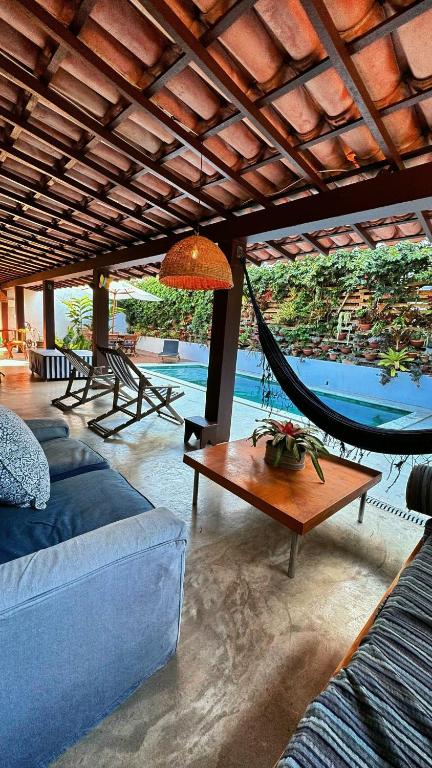 a living room with a hammock and a pool at Sun House Manguinhos in Búzios