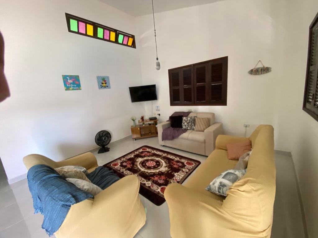 ein Wohnzimmer mit zwei Sofas und einem Fernseher in der Unterkunft Casa Porto de Galinhas in Porto De Galinhas