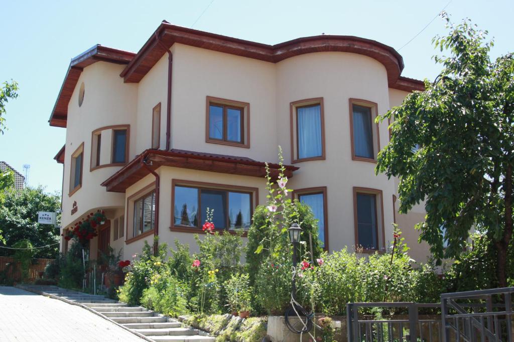 a large house with flowers in front of it at Pensiunea Kenza in Târgu-Mureş