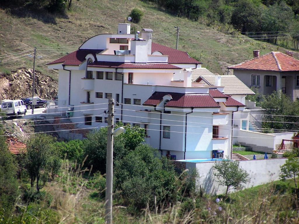 una gran casa blanca en la cima de una colina en Hotel Aleksievata Kashta en Gurgulyat
