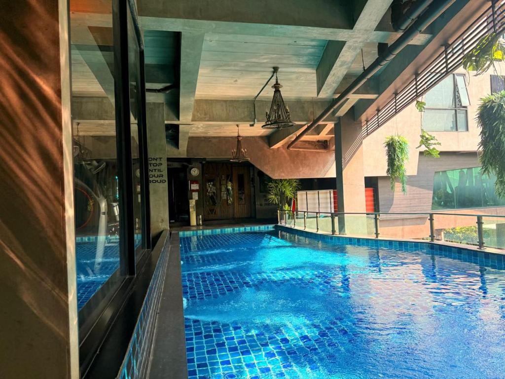 A compact indoor or semi-enclosed swimming pool beneath a covered terrace.
