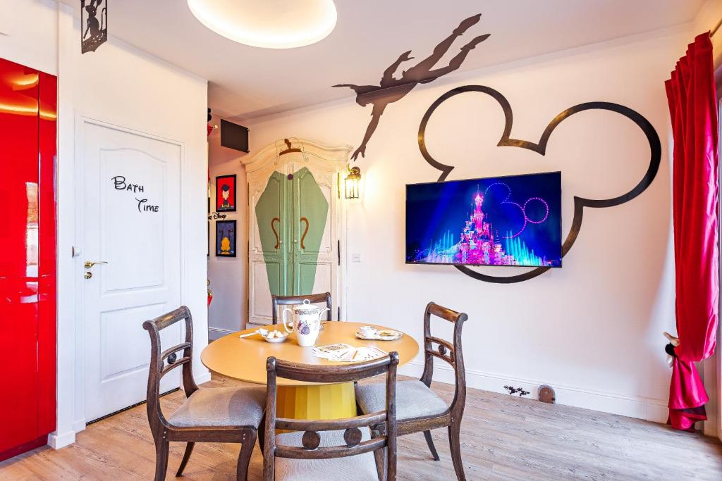 une salle à manger avec une table et une télévision au mur dans l'établissement Le Voyage Enchanté - T3 Féérique & équipé, à Toulouse
