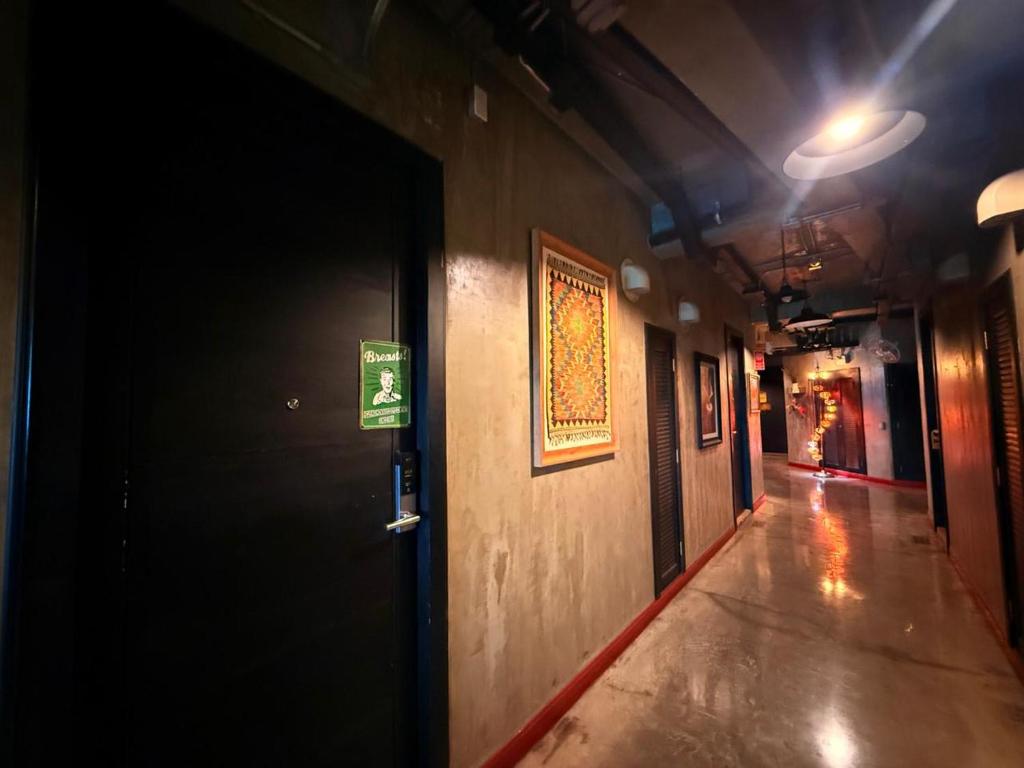 A dark, polished hallway leads past guestroom doors and framed artwork.