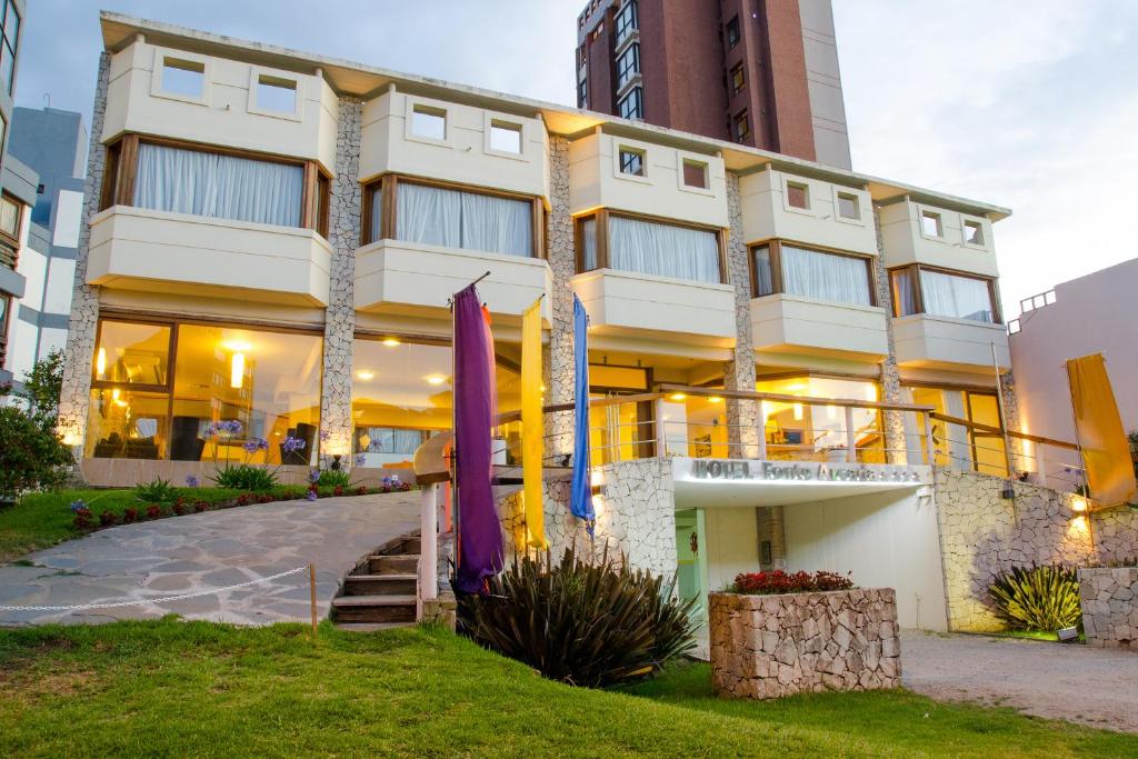 a building with purple umbrellas in front of it at Fonte Arcada in Villa Gesell