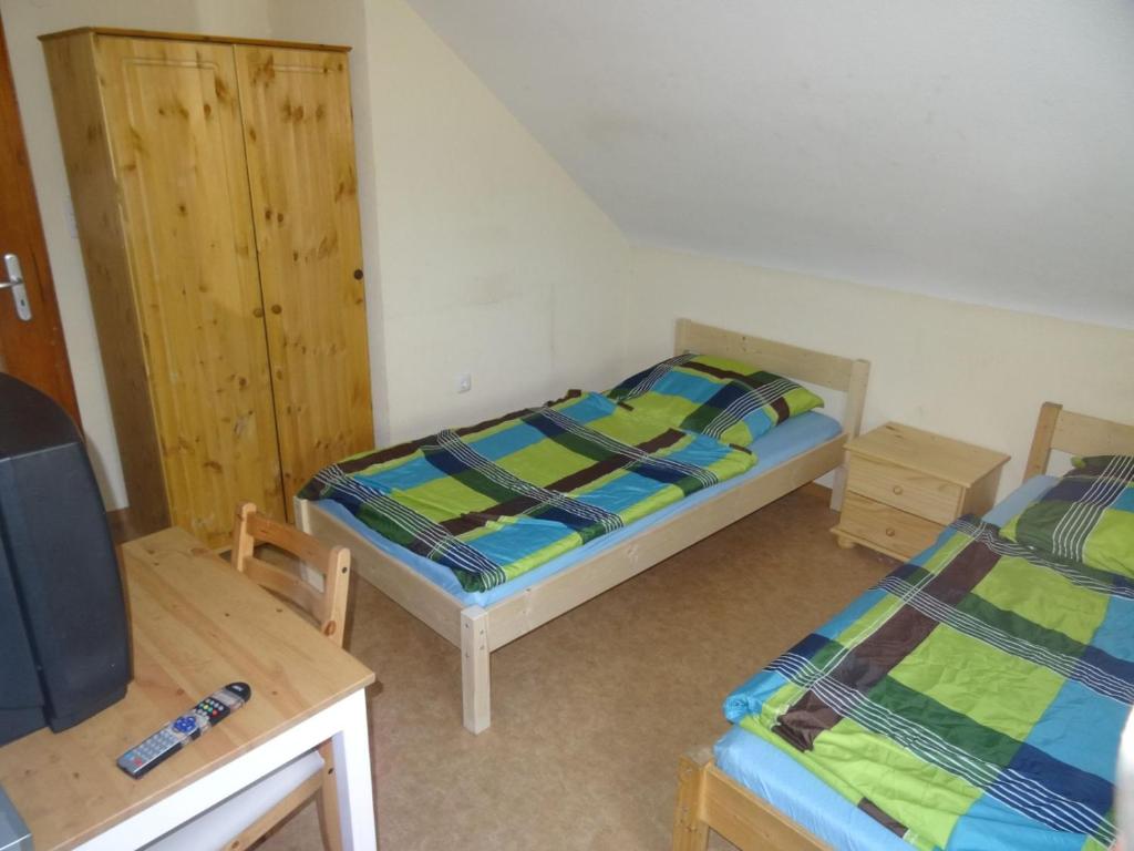 a small room with two beds and a tv at Monteurpension Haus Monika in Marktheidenfeld
