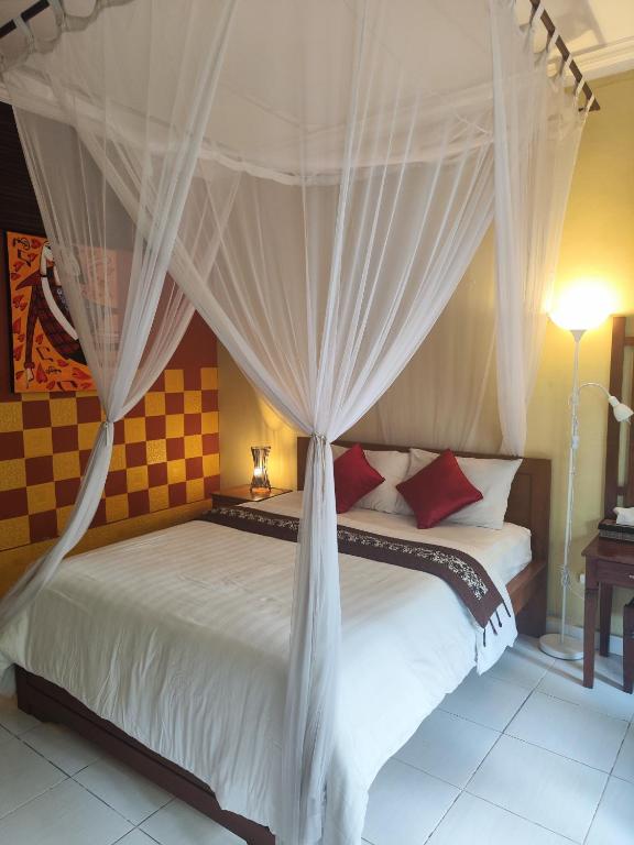 a bedroom with a bed with a canopy at Dalum Homestay in Amed