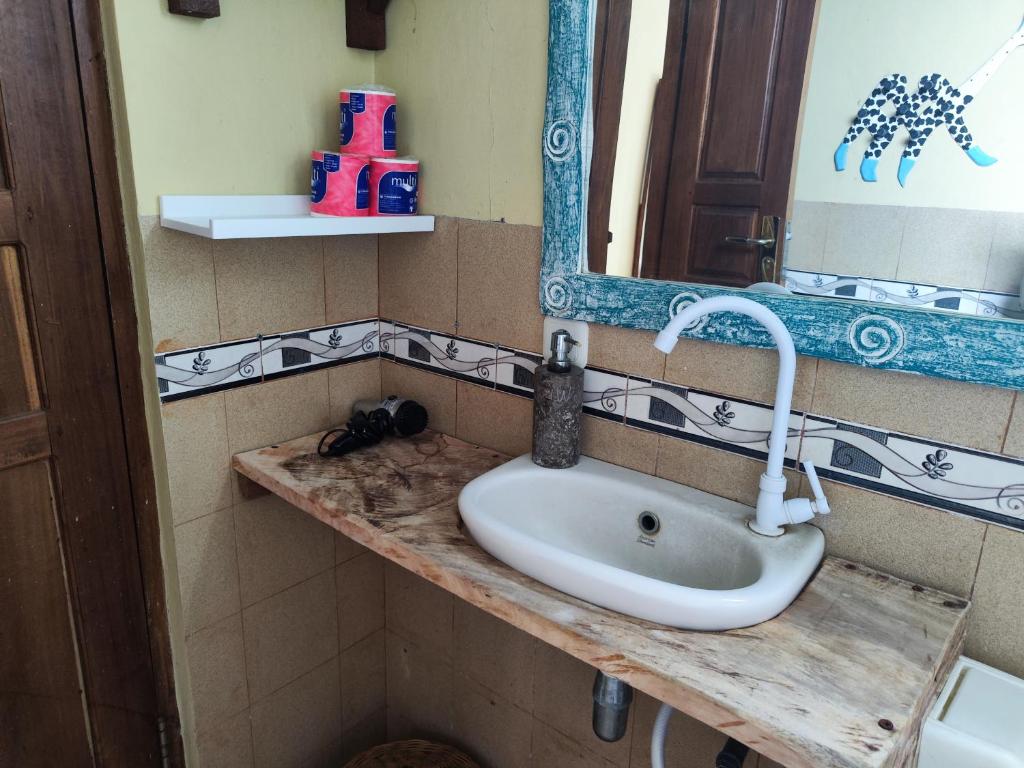 un bagno con lavandino e specchio di Dalum Homestay ad Amed