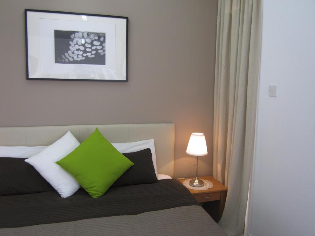 a bedroom with a green pillow on a bed at DownTown Living By 'Flats Nicosia' in Nicosia