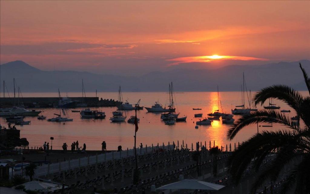 una puesta de sol sobre un puerto con barcos en el agua en B&B Portobello, en Sestri Levante