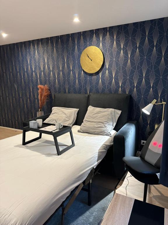 a room with a bed and a couch and a clock on the wall at THEM'APPARTS Bordeaux Chartrons in Bordeaux