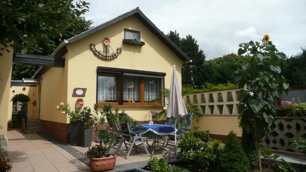 una pequeña casa amarilla con mesa y sillas en Ferienhaus Weber Bad Frankenhausen, en Bad Frankenhausen