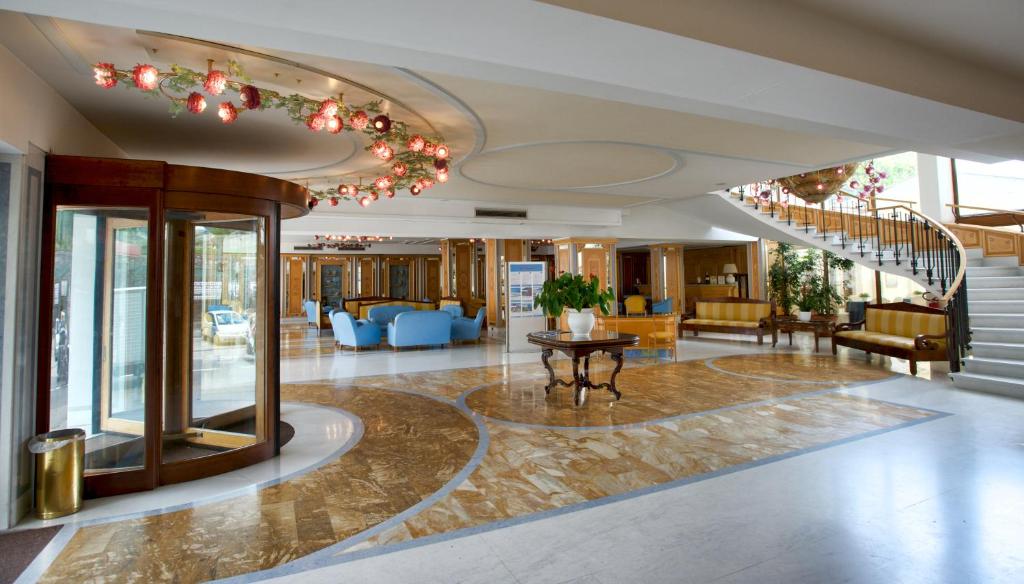 a lobby of a hotel with a spiral staircase at Grand Hotel Flora in Sorrento