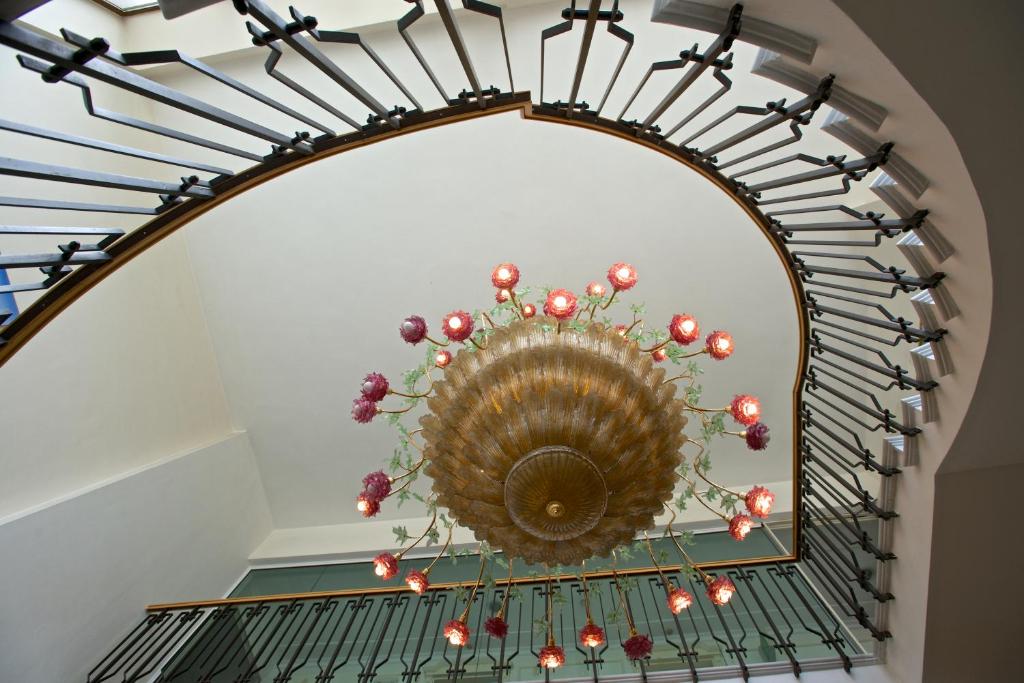 a spiral staircase with a chandelier in a building at Grand Hotel Flora in Sorrento
