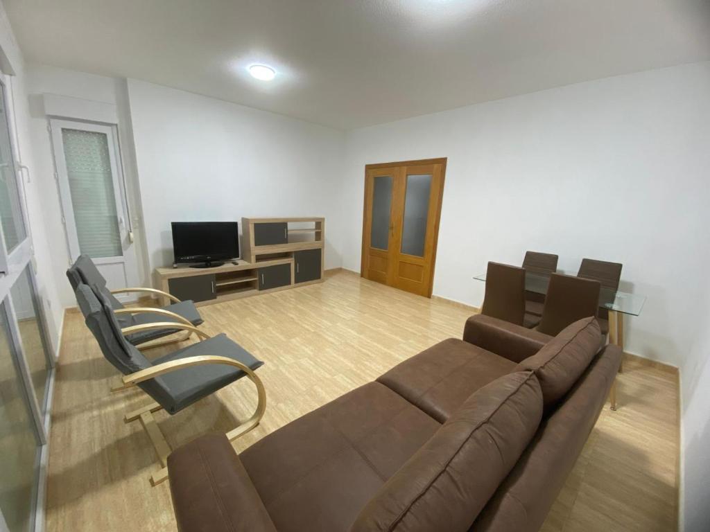 a living room with a brown couch and chairs at Casa fina y pepe in Algar