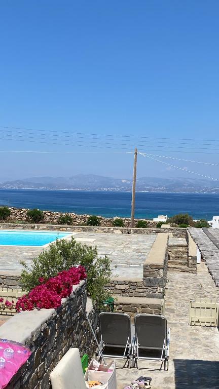 een groep stoelen en bloemen naast een zwembad bij Delta Apartment with Sea View and Pool in Chrissi Akti