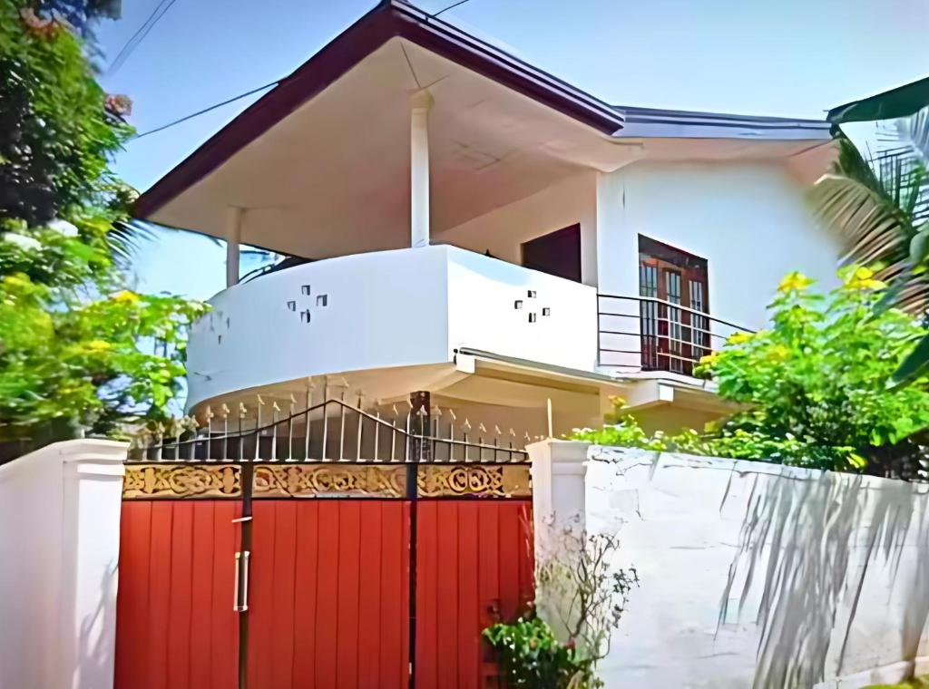 una casa con una puerta roja en Gayathri Guest Mirissa, en Mirissa
