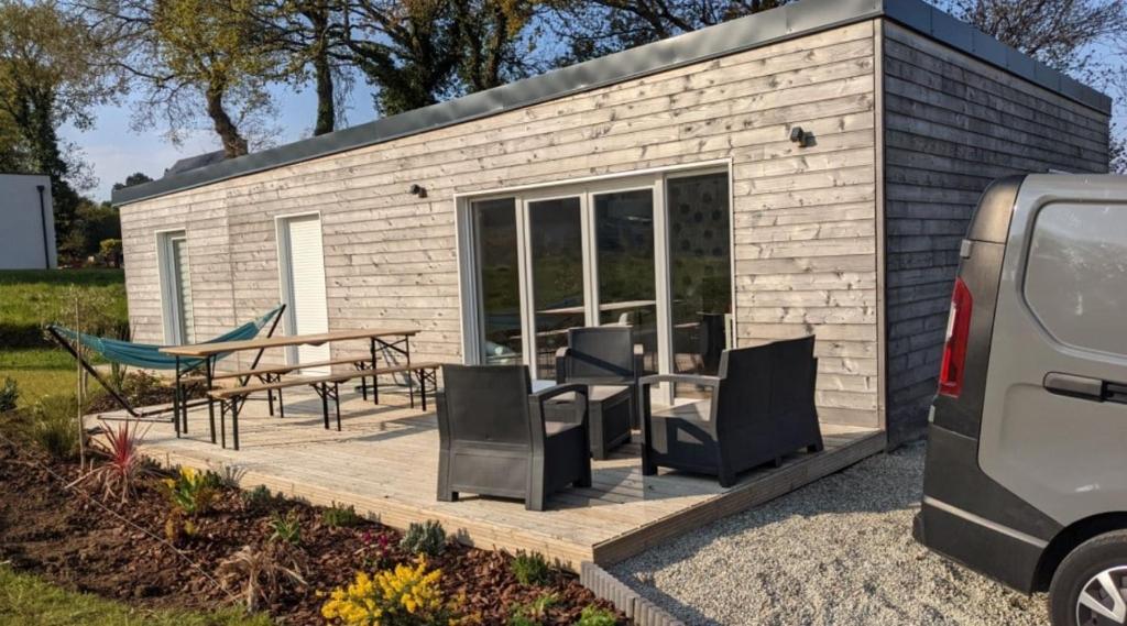 Une petite maison avec une table de pique-nique et des chaises dans l'établissement Wooden house, à Douarnenez