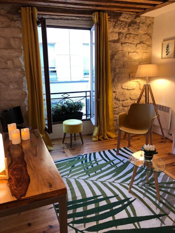 - un salon avec une table et une chaise verte dans l'établissement Coup de cœur à Montorgueil, à Paris