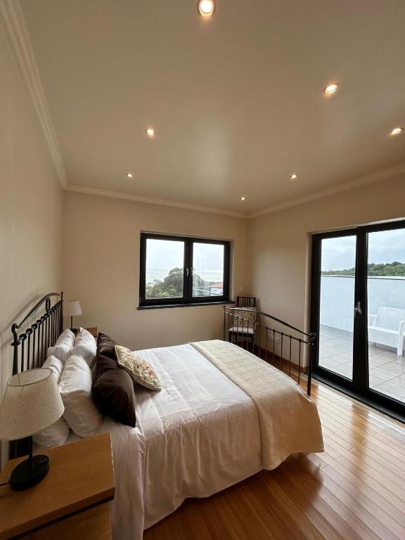 a bedroom with a large bed and a large window at Deluxe House in Angra do Heroísmo
