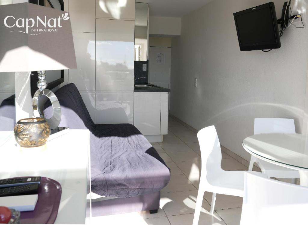 un salon avec un canapé, une table et une télévision dans l'établissement CapNat - Village Naturiste - Port Nature - Appartement 2 pièces - Le Chardonnay, au Cap d'Agde