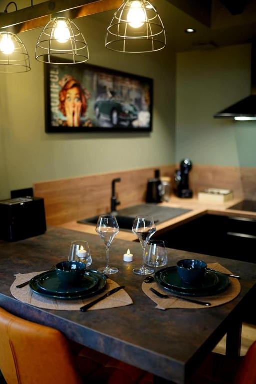 une cuisine avec une table avec des assiettes et des verres à vin dans l'établissement Gîte Nuit Féline, à Cirière