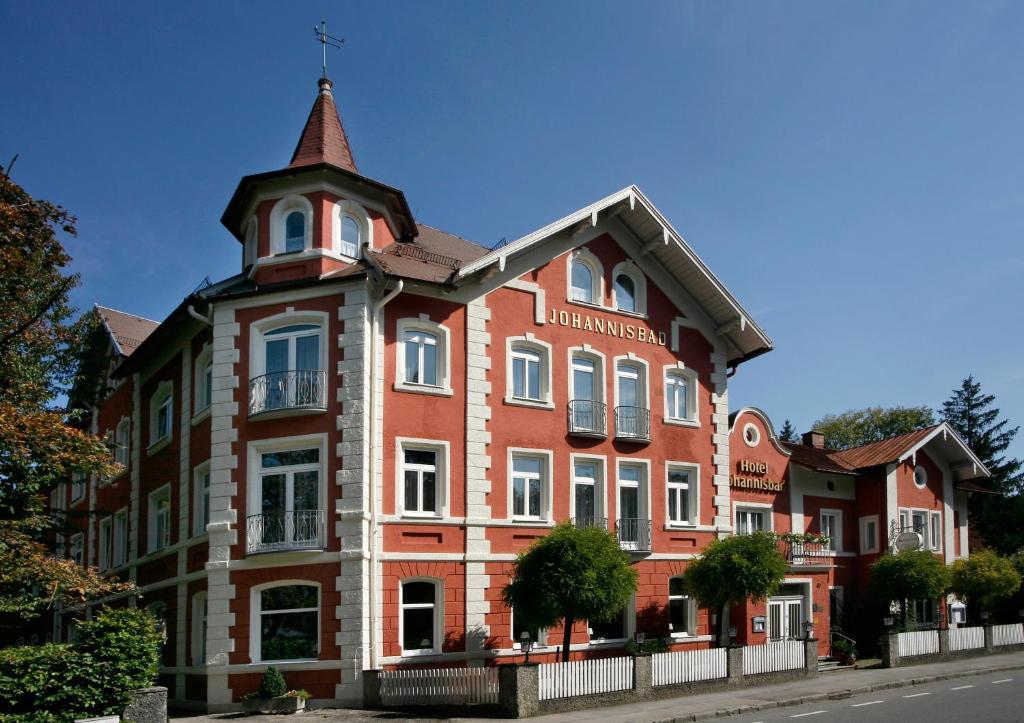a large red brick building with a tower on top at Hotel Johannisbad in Bad Aibling
