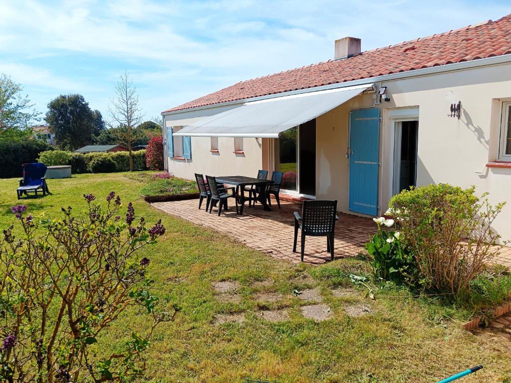 une maison avec une table et des chaises dans la cour dans l'établissement Le Secret des Marees, à Givrand
