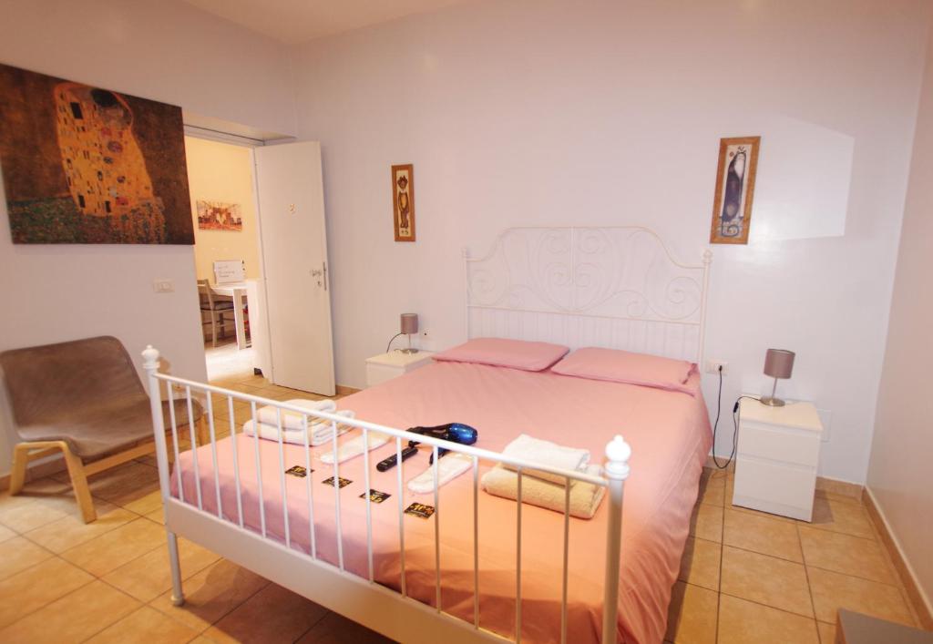 a bedroom with a bed with pink sheets and a chair at Old Bakery Rome GuestHouse in Rome