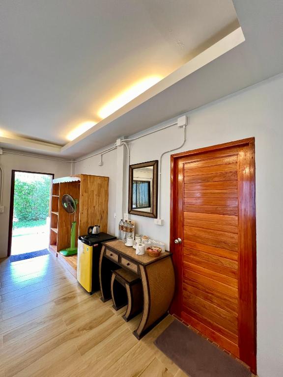 Zimmer mit einer Holztür und einer Küche in der Unterkunft Pen's Bungalow Koh Phangan in Thong Nai Pan Yai