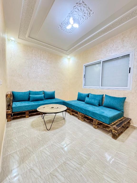 フェズにあるMenzeh saiss appartementの青いソファとテーブルのあるリビングルーム