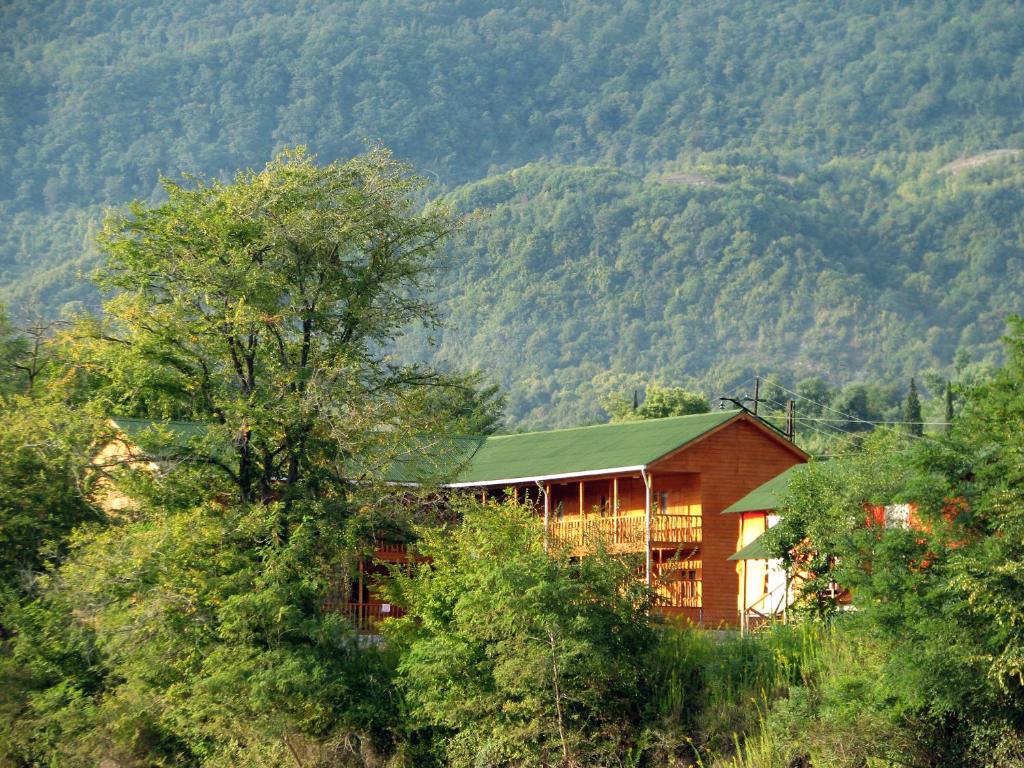 a red house in the middle of a mountain at Mandarin Pension in Novy Afon