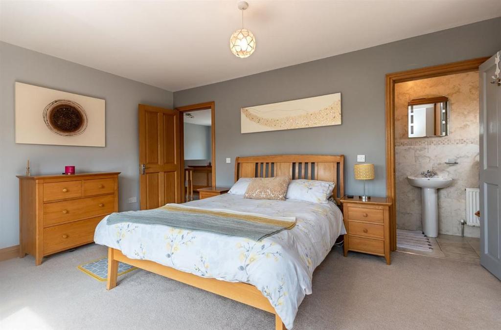 um quarto com uma cama grande e um lavatório em Kenmare HH em Kenmare