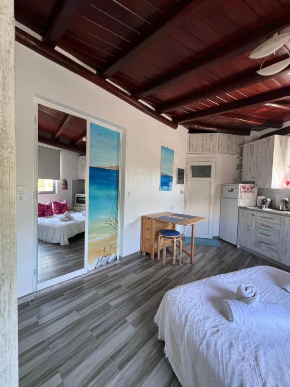a bedroom with a bed and a table and a kitchen at Agge Mykonο stay in Platis Yialos Mykonos