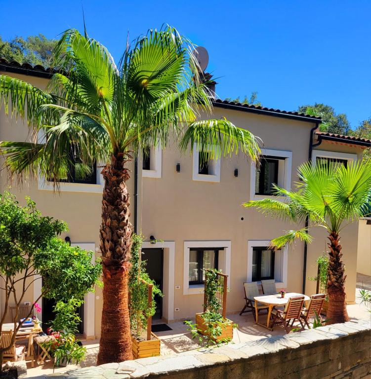 un bâtiment avec des palmiers devant dans l'établissement Villa Riviera, à Saint-Paul-de-Vence
