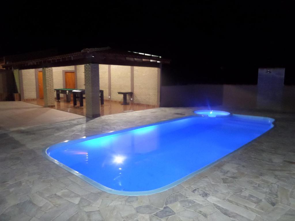 una gran piscina azul en una habitación con mesa en Pousada Cheiro De Mato, en Olímpia
