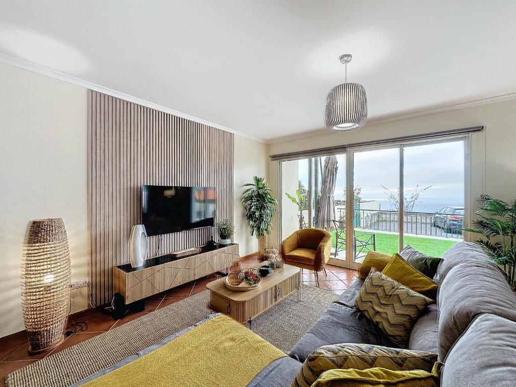 a living room with a couch and a tv at Ocean View Botânico in Funchal