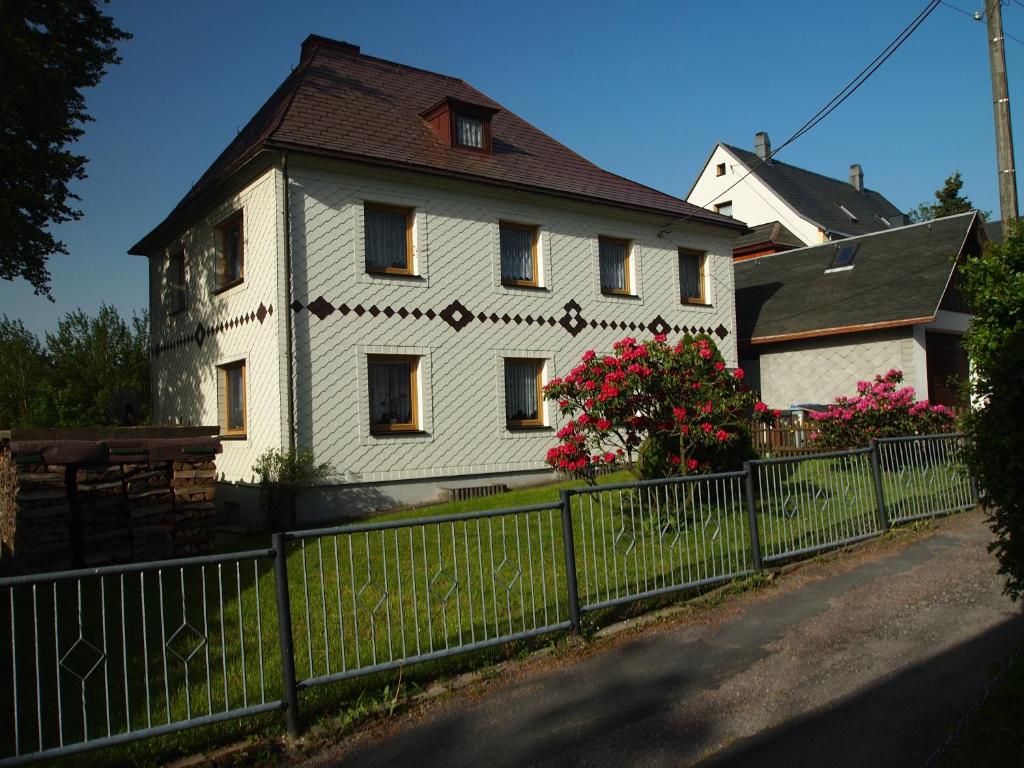 uma casa branca com uma cerca à frente. em Rennsteigwohnung Rust em Schmiedefeld am Rennsteig