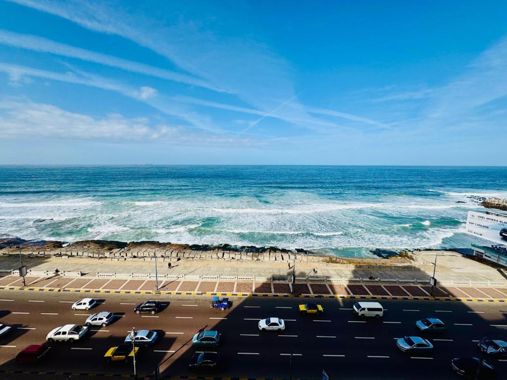 a view of a beach with cars and the ocean at ALEX HOMES - Sporting Sidi Gaber Cozy Apartments with Direct Sea View - Families only in Alexandria