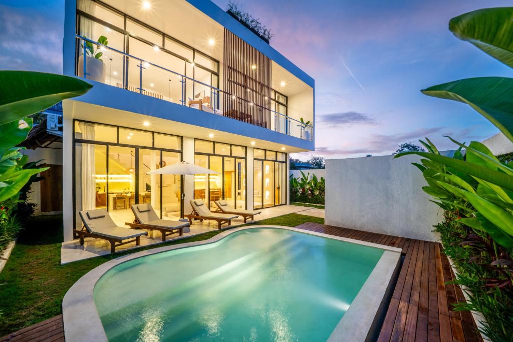 an exterior view of a house with a swimming pool at Villa Omnia Oasis Two Bedroom Garden Villa in Tumbak Bayuh