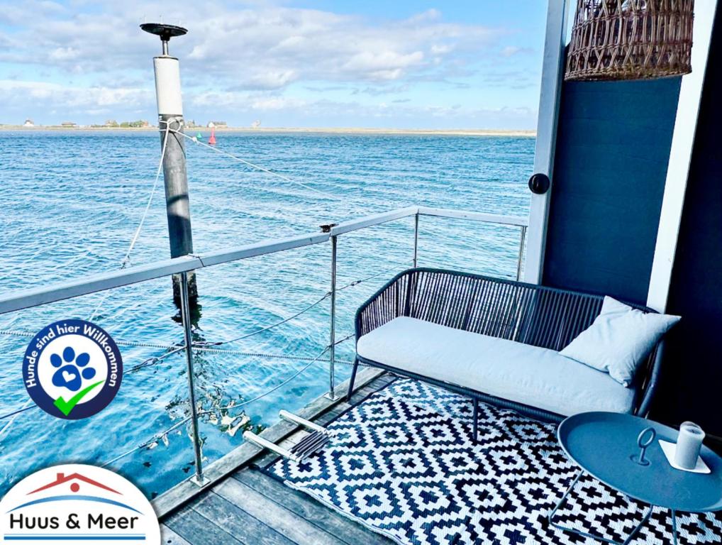 een bank op het dek van een boot in het water bij Hausboot Koje INE Huus & Meer in Ortmühle